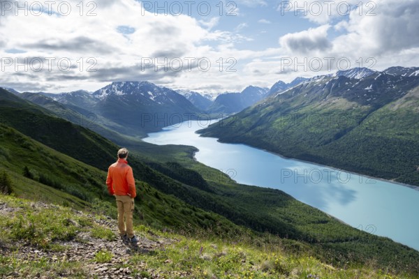 Mountaineer enjoys views of blue lake and mountains on Twin Peaks Trail, Eklutna Lake, Chugach