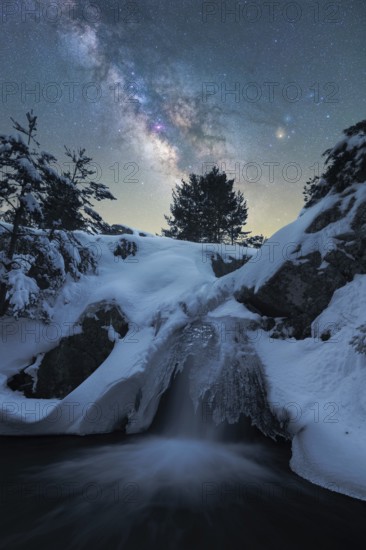 Captivating night scene depicting the Milky Way over a snow-laden landscape in Iceland A frozen