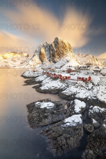 Rorbuer fishing huts in front of snow-covered mountains in winter, Hamnøy, Moskenesøy, Lofoten,