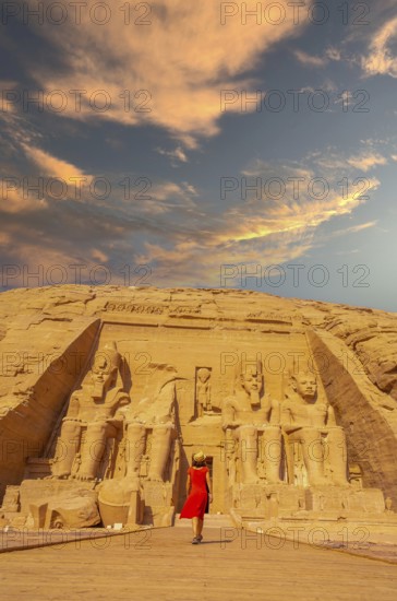 A European tourist in red dress walking towards the Abu Simbel Temple in southern Egypt in Nubia