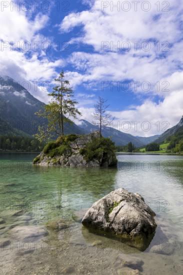 Hintersee near Ramsau with clear green water, surrounded by forests and mountains under a cloudy