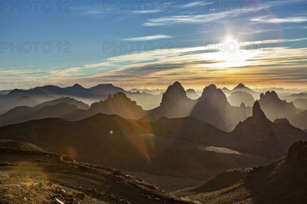 Sunbeams break through the haze over a mountain landscape at sunset, The landscape of the Ahaggar