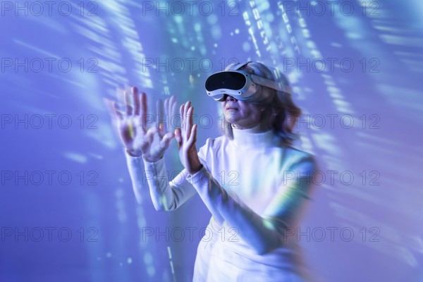 An elderly Asian woman engages with the metaverse using a virtual reality headset. She extends her