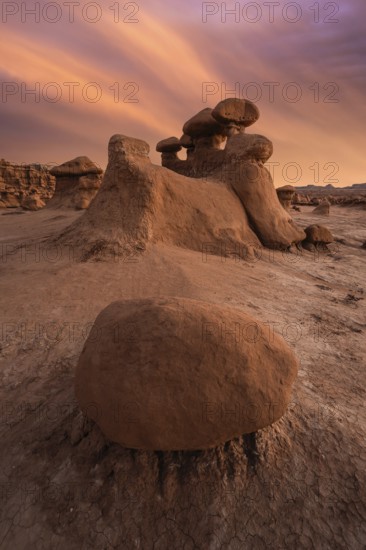 Dramatic sandstone formations under a vibrant sunset sky in Goblin Valley State Park, Utah, USA.