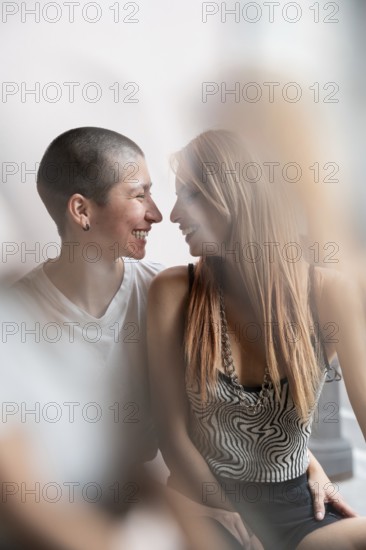 A loving lesbian couple shares an intimate moment, embracing warmly and gazing into each other's