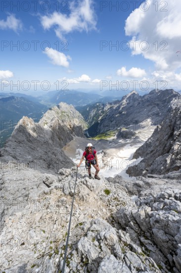 Mountaineer with helmet in a secured via ferrata, Zugspitze via ferrata, ascent to the Zugspitze,