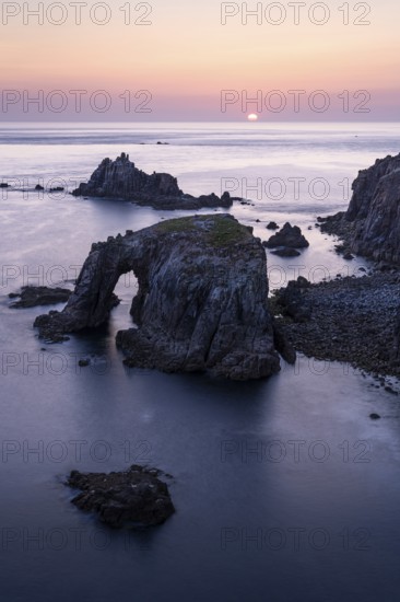 Coastal landscape at Land's End. The Enys Dodnan Arch with rock gate. In the evening at sunset.