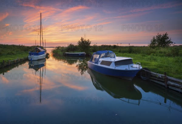 Sunset on the Achterwasser, boats moored in a small natural harbor, near Zinnowitz, Usedom island,