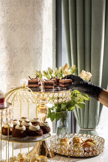 A luxurious dessert spread featuring various cakes and pastries displayed on elegant, crystal