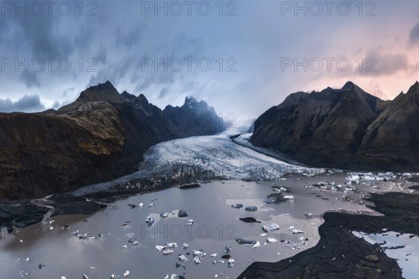 Majestic twilight view of Vatnajökull Glacier, Iceland, with scattered icebergs and dramatic