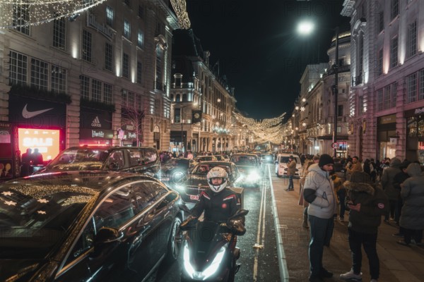 Busy street at night with traffic and brightly lit buildings and roads, New Year's Eve London,