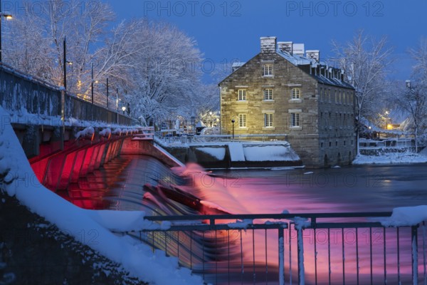 Illuminated Moulin Neuf water flow control dam and walkway over Des Mille-Iles river plus New Mill