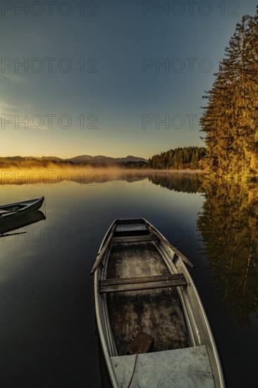 Boats in the autumnal Schmutter Weiher in the Allgäu near the municipalities of Halblech,
