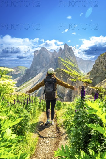 Hiker walking along a path with open arms, enjoying the view of the odle mountains in the italian