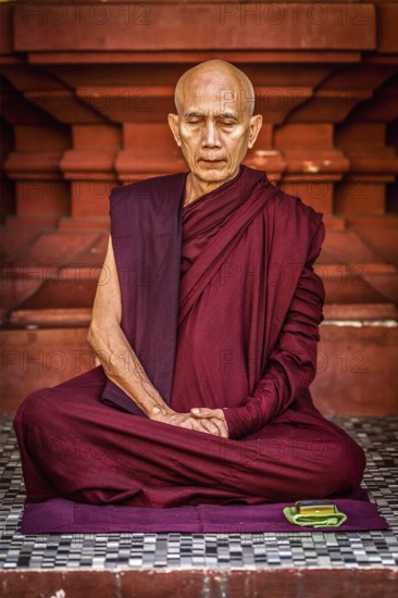 YANGON, MYANMAR, JANUARY 3, 2014: Ascetic Buddhist monk meditating in Shwedagon Paya pagoda