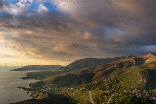 Golden hour view of the rugged hills and coastal villages of the Mani Peninsula, with winding roads