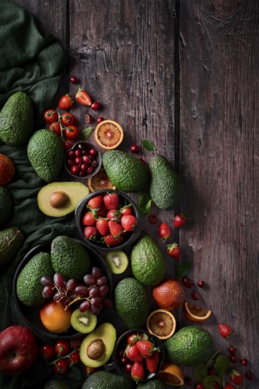 A vibrant assortment of fresh fruits and vegetables, including avocados, strawberries, grapes, and