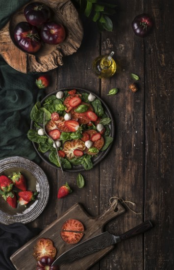 Healthy tomato and strawberry salad on a wooden rustic table