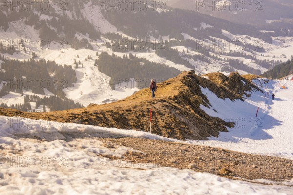 Landscape with snow-covered mountains and a narrow hiking trail that snakes through the winter