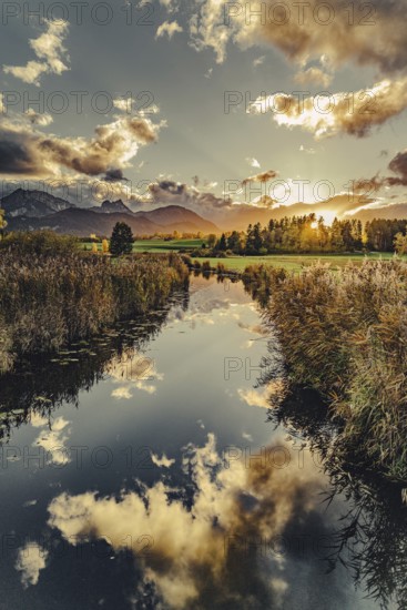 Lake Hopfensee in the Allgäu in autumn with warm sunset light against a picturesque Alpine