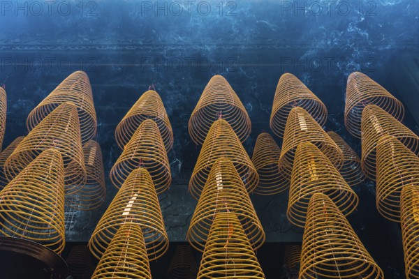Numerous large, spiral incense coils hanging in a Taoist and Chinese Buddhist temple in Macau,