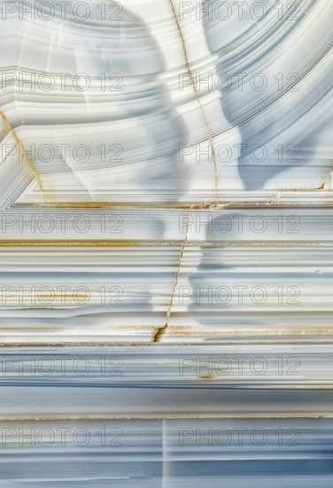 A macro photograph showcasing the striking linear patterns and mineral details inside a Whitcomb