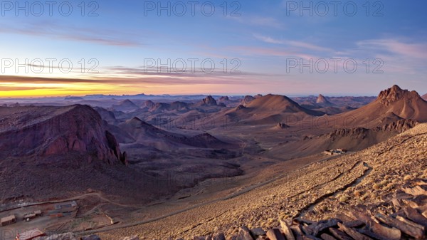 Vast desert landscape at sunset with mountain ranges on the horizon, The landscape of the Ahaggar