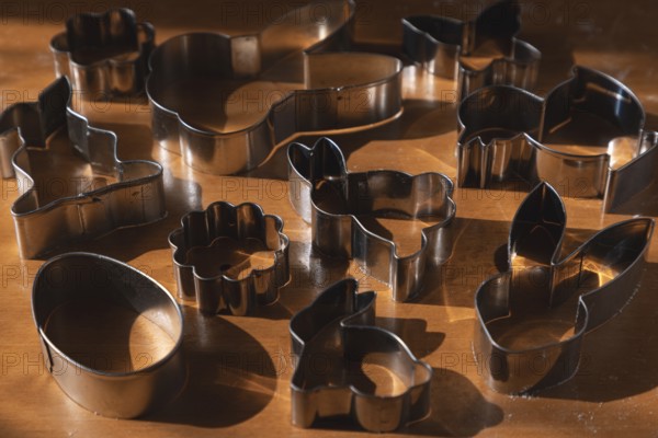 Different metal cookie cutters for Easter on a wooden surface