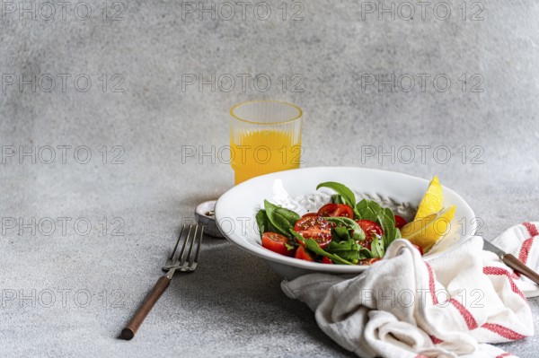 A refreshing arugula and herb salad, elegantly garnished with Himalayan salt, olive oil, cherry