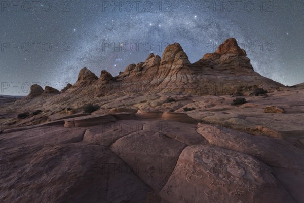 A breathtaking view of jagged rock formations under a vast, starry night sky, capturing the beauty