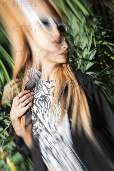 A stylish woman in sunglasses captured with motion blur effect, creating a dynamic and artistic