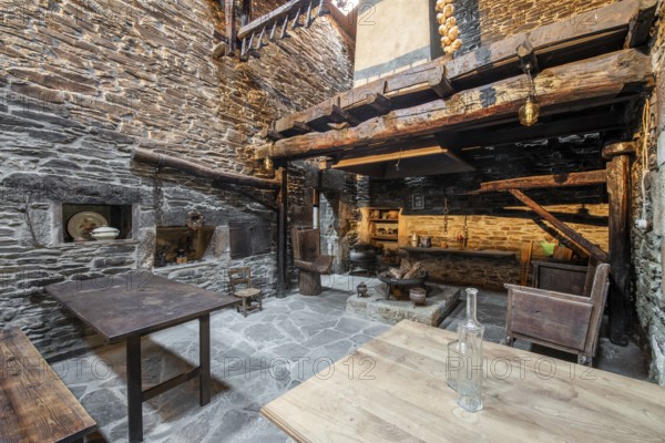 Traditional stone-walled kitchen inside an old country house in Lugo, Spain, featuring wooden