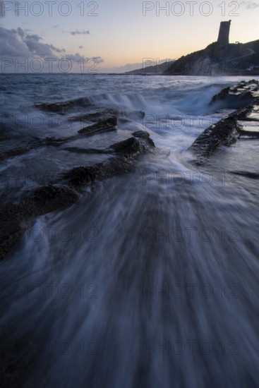 A mesmerizing sunset over the coast of Cadiz in Tarifa. Waves crash onto rocky shores as the sky