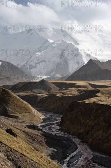 Achik Tash river, Achik Tash valley, behind glaciated and snow-covered mountain peak Pik Lenin,