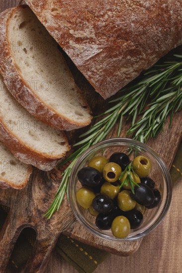 Sliced ciabatta, on a chopping board, with rosemary and olives, Italian bread, close-up, Italian