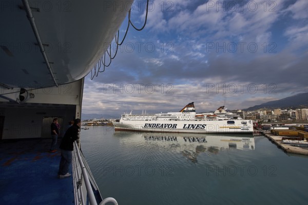 View from a ferry of the harbor with ships and dramatic clouds, Old ferry port in central Patras,