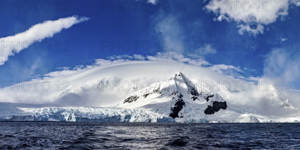 Panoramic view of impressive snow-capped mountains under dramatic clouds, The landscape in the