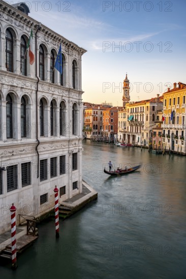 View of the Grand Canal with gondoliers at sunset, picturesque evening mood with palazzos on the