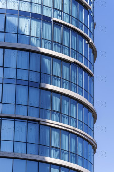 Modern architecture, highlighting a curved building with a vibrant blue glass facade against a