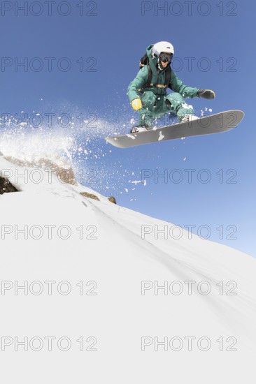 A snowboarder expertly navigates a thrilling freeride descent, capturing the essence of extreme