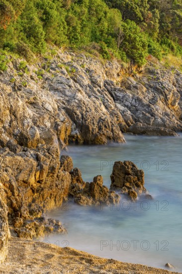 Crystal clear and turquoise water on the beach of Ustrine Bay on a sunny day at sunset on the