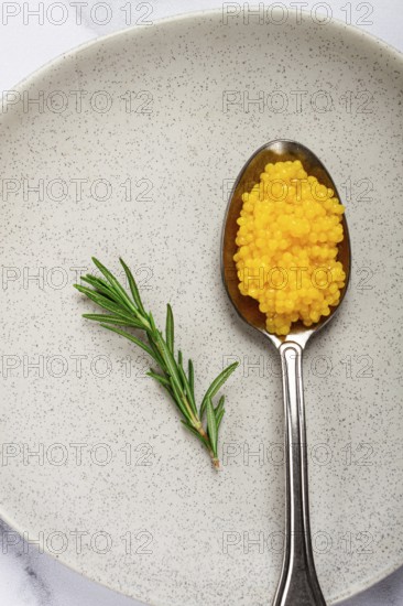 Yuzu caviar is pearly, on a spoon, top view, light background, no people
