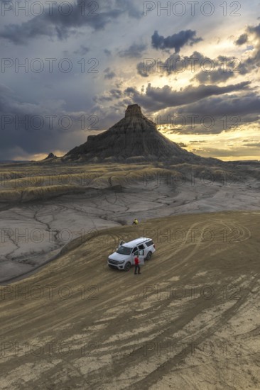 From above an unrecognizable person standing next to a SUV at Factory Butte, Utah, captured during