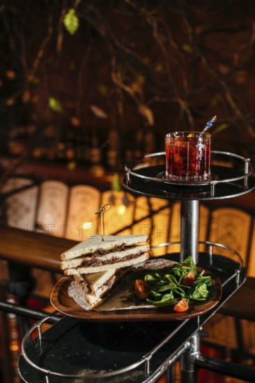 A delectable club sandwich with veal cheeks and cheese, paired with a refreshing Negroni cocktail.