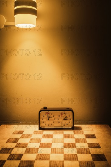 An inviting scene in Swedish Lapland featuring a chessboard and clock bathed in a warm glow from a