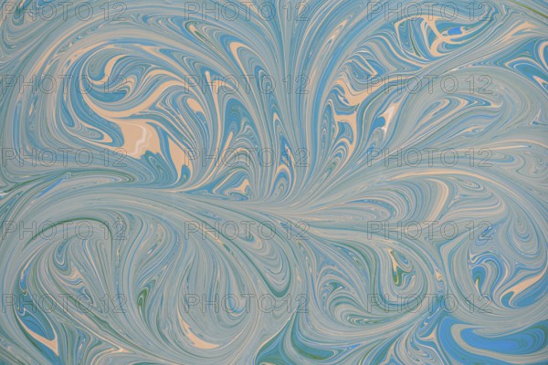 An abstract floral pattern with swirling blue and beige acrylic paint. This dynamic design creates
