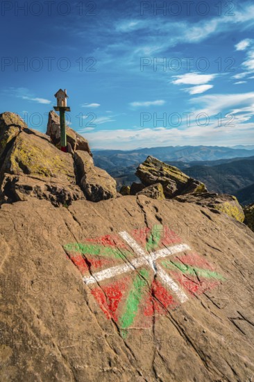 The flag of the Basque country and a figure of a house above Mount Adarra in Guipuzcoa one winter