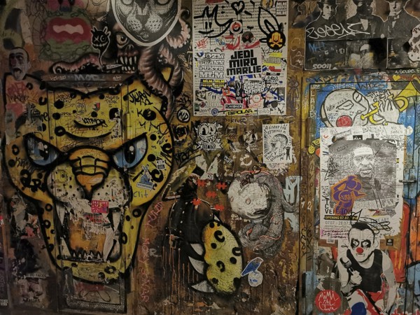 Colourful graffiti and poster wall with lively urban works of art, Berlin