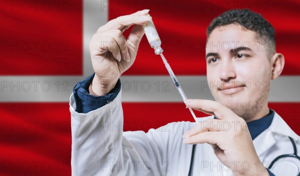 Doctor holding syringe on Denmark flag background. Medical professional holding syringe with Danish