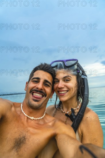 Couple taking a selfie with snorkeling gear in the ocean at white beach, cebu island, philippines,